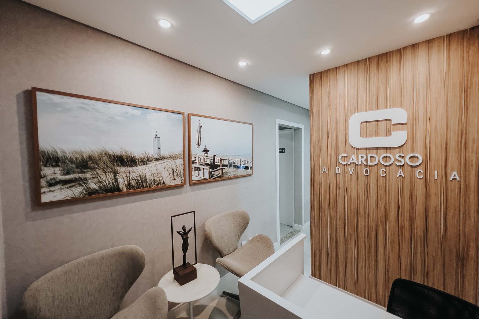 Recepção da sede da Cardoso Advocacia, com a marca em letras aplicadas na parede de madeira